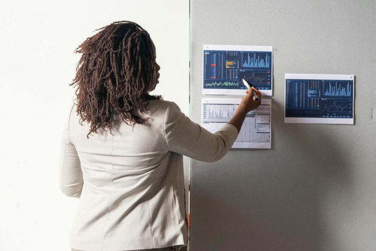 Modern office scene with a businesswoman looking at multiple floating holographic screens showing AI workflow diagrams, data analysis charts, and automated process flows. Futuristic blue and white color scheme, professional atmosphere, clean minimalist style. Keywords: artificial intelligence, automation, business technology — Formations 90