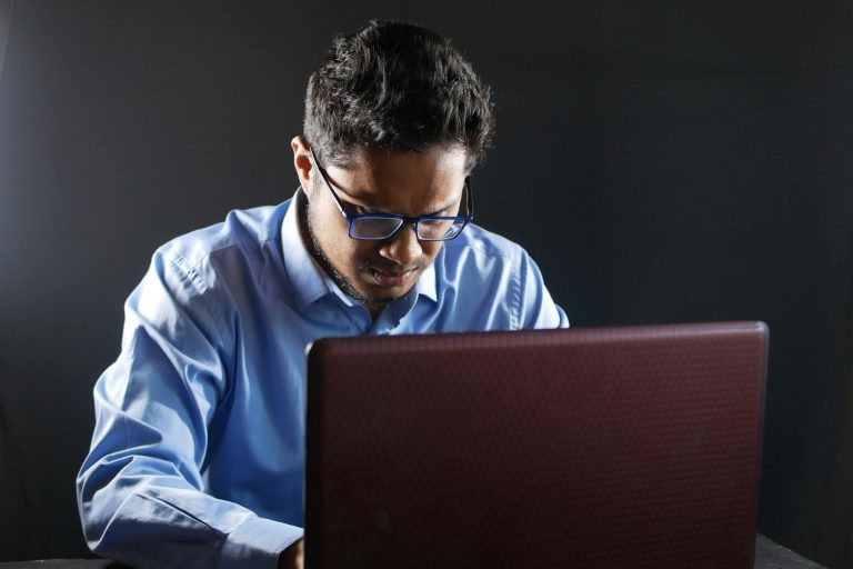 Professional business scene with a confident person working on laptop in modern office environment, safety net or insurance concept, warm natural lighting, corporate yet reassuring atmosphere, split screen showing traditional office vs entrepreneurial workspace, keyword: business insurance professional — Formations 90