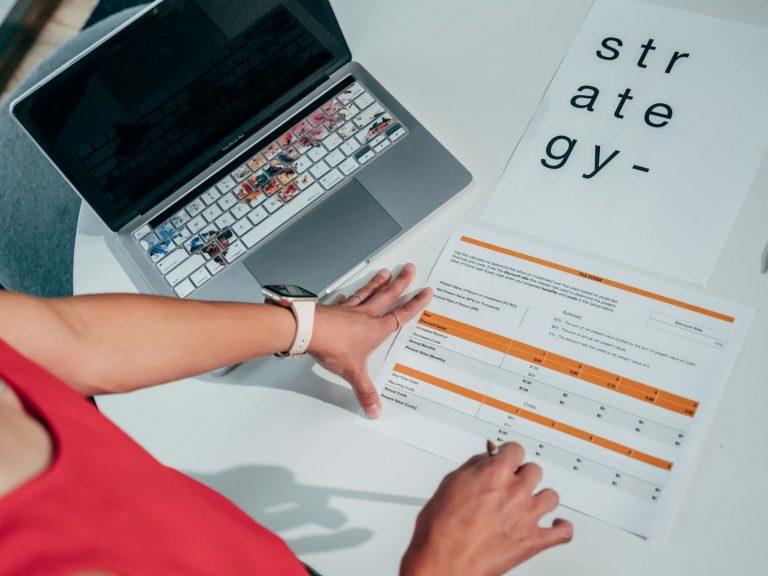 Professional training scene: person at modern desk with laptop, documents spread out, France Travail logo visible, bright office environment, digital transformation concept, keywords: training office professional development — Formations 90